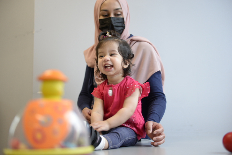 Ayla Bashir sits with her mother, Sobia Qureshi, during a physical therapy assessment for Ayla at CHEO in Ottawa on Aug. 23, 2022. André Coutu/CHEO via AP